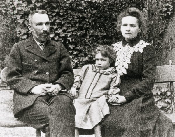 The Curie Family; Marie, Pierre and daughter Irene, sit on an outdoor bench posing for a picture. --- Image by © CORBIS